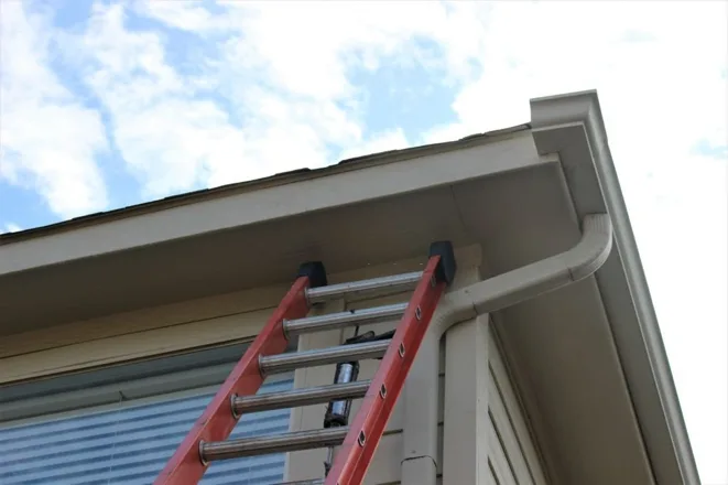 installing gutters at baton rouge two story home with tall ladder